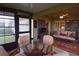 Cozy sunroom with a glass table, plush seating, and scenic views blending indoor comfort with the beauty of the outdoors at 29435 Snap Hook Dr, San Antonio, FL 33576