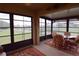 Bright sunroom features a glass table, comfortable chairs, and large windows showcasing the beautiful outdoor views at 29435 Snap Hook Dr, San Antonio, FL 33576