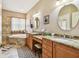 Bathroom featuring double sinks, granite countertops, a soaking tub and a tiled shower at 3484 Primrose Way, Palm Harbor, FL 34683