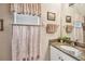 Bathroom featuring granite countertop, framed mirror, and decorative shower curtain at 3484 Primrose Way, Palm Harbor, FL 34683