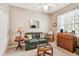 Inviting bedroom featuring a sofa, ceiling fan, window, desk, and carpet flooring, creating a comfortable living space at 3484 Primrose Way, Palm Harbor, FL 34683
