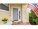 Inviting front entrance with a storm door, 'hello' doormat, and American flag at 3484 Primrose Way, Palm Harbor, FL 34683