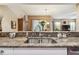 Kitchen area featuring granite countertops and a stainless steel sink with a view into the dining area at 3484 Primrose Way, Palm Harbor, FL 34683