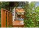 Home's wooden patio overlooks a canopy-covered lounge area and landscape at 3484 Primrose Way, Palm Harbor, FL 34683