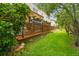 Home's wooden patio overlooks the lush green lawn, landscaping and a canopy-covered lounge area at 3484 Primrose Way, Palm Harbor, FL 34683
