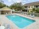 Community pool area featuring ample seating, a bathhouse, and well maintained lounge area at 3484 Primrose Way, Palm Harbor, FL 34683