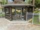 A charming poolside gazebo featuring a table, chairs, and screened windows, perfect for relaxation at 3484 Primrose Way, Palm Harbor, FL 34683
