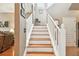 Staircase with wooden steps, white railings, and natural light from a window above at 3484 Primrose Way, Palm Harbor, FL 34683