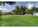 Large, fenced backyard with green grass, offering plenty of space for recreation and entertaining at 38320 14Th Ave, Zephyrhills, FL 33542