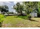 Spacious backyard featuring a lush lawn, mature trees, and a storage shed for all your outdoor needs at 38320 14Th Ave, Zephyrhills, FL 33542