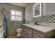 Modern bathroom with updated vanity, mosaic tile, and illuminated mirror at 38320 14Th Ave, Zephyrhills, FL 33542