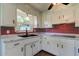 Well-lit kitchen with white cabinets, a brick backsplash, and modern appliances at 38320 14Th Ave, Zephyrhills, FL 33542