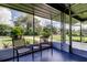 Relaxing screened-in porch with comfortable seating and views of the lush front yard at 38320 14Th Ave, Zephyrhills, FL 33542
