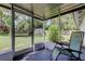 Inviting enclosed porch with views of the backyard and a relaxing chair at 38320 14Th Ave, Zephyrhills, FL 33542