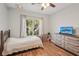 Bright bedroom with a large window, wooden floors, and natural light creating a relaxing atmosphere at 4020 Cottage Hill Ave, Parrish, FL 34219