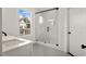 Modern bathroom with a glass shower door, hexagon tile floor, and view to outside at 406 E Selma Ave, Tampa, FL 33603