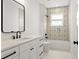 Elegant bathroom features white vanity, black hardware, decorative tile shower, and a framed mirror at 406 E Selma Ave, Tampa, FL 33603