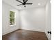 Bedroom with hardwood floors, ceiling fan and a large window offering natural light at 406 E Selma Ave, Tampa, FL 33603