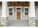 Detailed view of the home's entryway with a wooden front door and decorative stone pillars at 406 E Selma Ave, Tampa, FL 33603