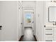 Hallway showcasing wood floors, leading to a bright room and a vanity with a framed mirror at 406 E Selma Ave, Tampa, FL 33603