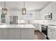 Modern kitchen featuring white cabinets, stainless steel appliances, a large island, and subway tile backsplash at 406 E Selma Ave, Tampa, FL 33603