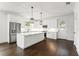 Bright kitchen featuring white cabinets, stainless steel appliances, a large island, and stylish pendant lighting at 406 E Selma Ave, Tampa, FL 33603