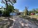 Inviting single-story home with a driveway and attached garage surrounded by lush greenery at 422 Crosswinds Dr, Palm Harbor, FL 34683