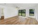 A bright living room with wood-look floors, a ceiling fan, and sliding glass doors to the backyard at 4625 Vernell St, North Port, FL 34291