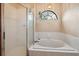 Bathroom featuring shower, garden tub with unique window and hanging plant at 4744 Burlington Rd, Land O Lakes, FL 34639