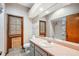 Well-lit bathroom featuring a large mirror, peach countertops, and tiled flooring at 4744 Burlington Rd, Land O Lakes, FL 34639