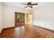 Bedroom with hardwood floors, ceiling fan, and glass paneled doors to the outside at 4744 Burlington Rd, Land O Lakes, FL 34639
