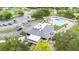 Aerial view of a community center next to a parking lot and a sparkling swimming pool with lounge area at 4744 Burlington Rd, Land O Lakes, FL 34639