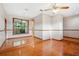 Well-lit dining area boasts hardwood floors, a ceiling fan, and a view of lush greenery outside at 4744 Burlington Rd, Land O Lakes, FL 34639