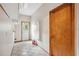 View of the tiled hallway with a door to the outside, interior door, and fire extinguishers at 4744 Burlington Rd, Land O Lakes, FL 34639
