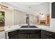Kitchen sink and countertop featuring black cabinets, stainless steel appliances and open view to living room at 4744 Burlington Rd, Land O Lakes, FL 34639