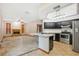 Open concept kitchen and living room with stainless appliances and stone fireplace at 4744 Burlington Rd, Land O Lakes, FL 34639