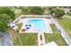 Aerial shot of a fenced community pool with plenty of lounge chairs and umbrella-shaded tables at 4744 Burlington Rd, Land O Lakes, FL 34639