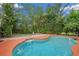 Beautiful pool area with a tiled edge, inviting lounge chairs, and lush greenery at 4744 Burlington Rd, Land O Lakes, FL 34639