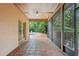 View of tiled porch with screen and french doors to the pool at 4744 Burlington Rd, Land O Lakes, FL 34639