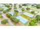 Overhead shot of multiple community tennis courts, nestled among mature trees in a serene setting at 4744 Burlington Rd, Land O Lakes, FL 34639