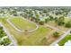 Aerial view of a well-maintained community track surrounded by lush greenery and neighborhood homes at 4744 Burlington Rd, Land O Lakes, FL 34639