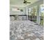 Outdoor kitchen featuring a grill, sink, and stone countertops in a screened-in patio at 4773 Hickory Oak Dr, Brooksville, FL 34601