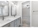 Bathroom with double sinks, vanity lighting, framed mirrors and gray cabinets at 4799 Hickory Oak Loop, Brooksville, FL 34601