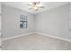 Neutral bedroom with a ceiling fan, a window with blinds, and white trim at 4799 Hickory Oak Loop, Brooksville, FL 34601