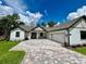 Beautiful home featuring a paved driveway, attached 2 car garage, and pristine landscaping at 4799 Hickory Oak Loop, Brooksville, FL 34601