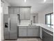 Stylish kitchen features stainless steel appliances, gray cabinetry, and quartz countertops at 5104 Munhal St, Port Charlotte, FL 33981