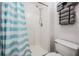 Bright bathroom featuring a white shower and toilet with a blue striped curtain for added appeal at 5334 Tummel Ct, Wesley Chapel, FL 33545