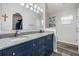 Bathroom featuring double sinks, granite countertop, navy blue cabinets, and a large mirror at 5334 Tummel Ct, Wesley Chapel, FL 33545