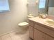 Modest bathroom with a toilet, and a pink vanity with a sink and a window letting in natural light at 5530 Salem Square N Dr, Palm Harbor, FL 34685