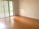 Well-lit bedroom with wood floors, a sliding glass door, and a bright window at 5530 Salem Square N Dr, Palm Harbor, FL 34685